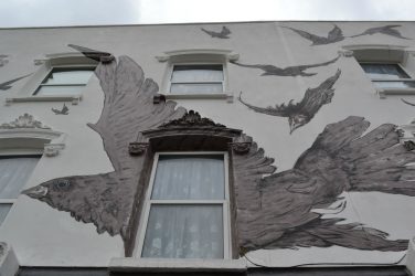 Exterior of the Birds pub - a wall of bird paintings
